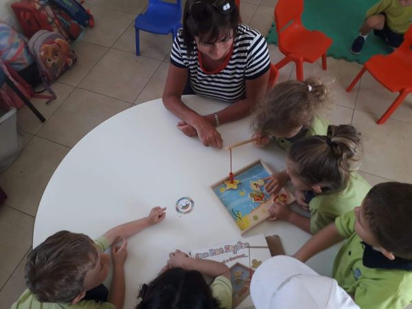 photo of special needs assistant with children in classroom